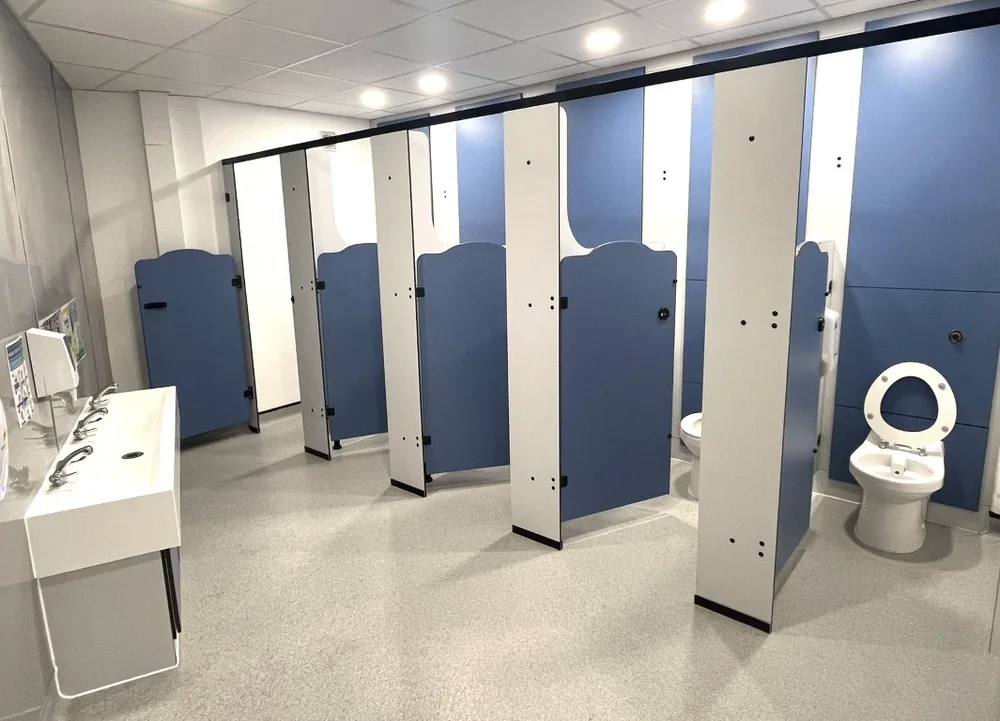 Rainbow school toilet cubicles in a boys' washroom