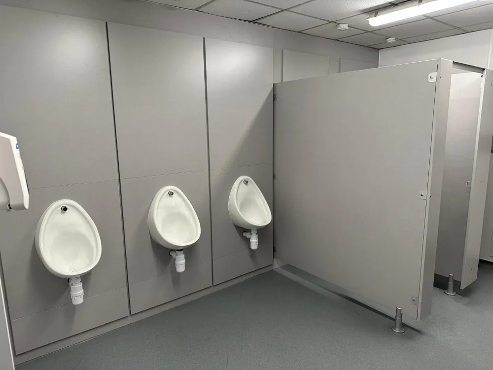 Volante IPS urinal panels in a commercial washroom